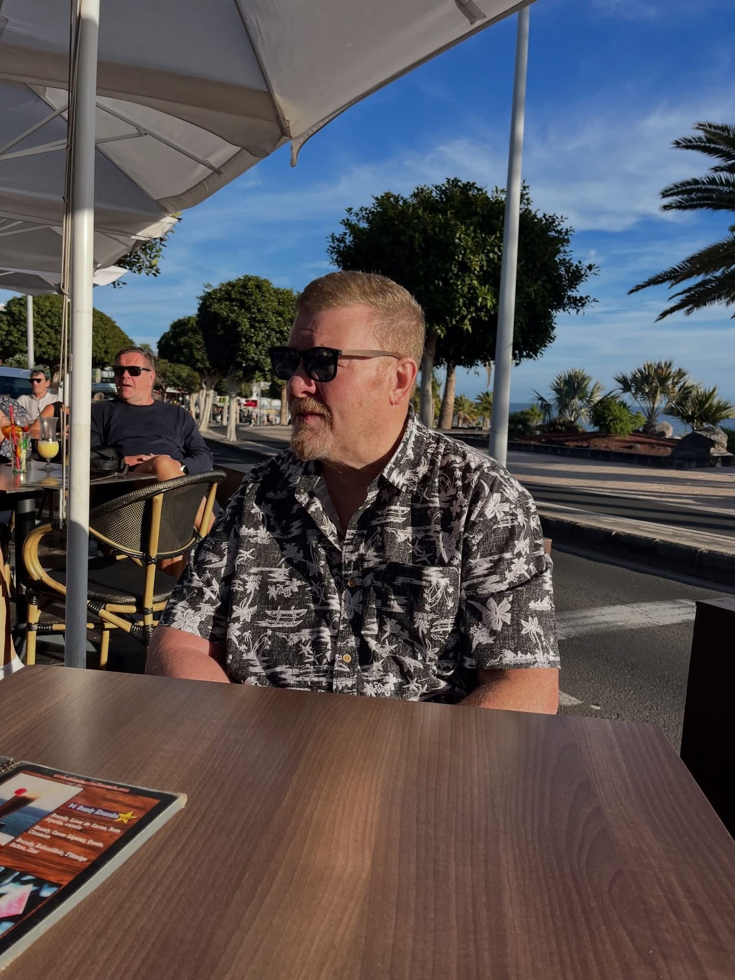 Andy sitting at an outdoor café while on holiday